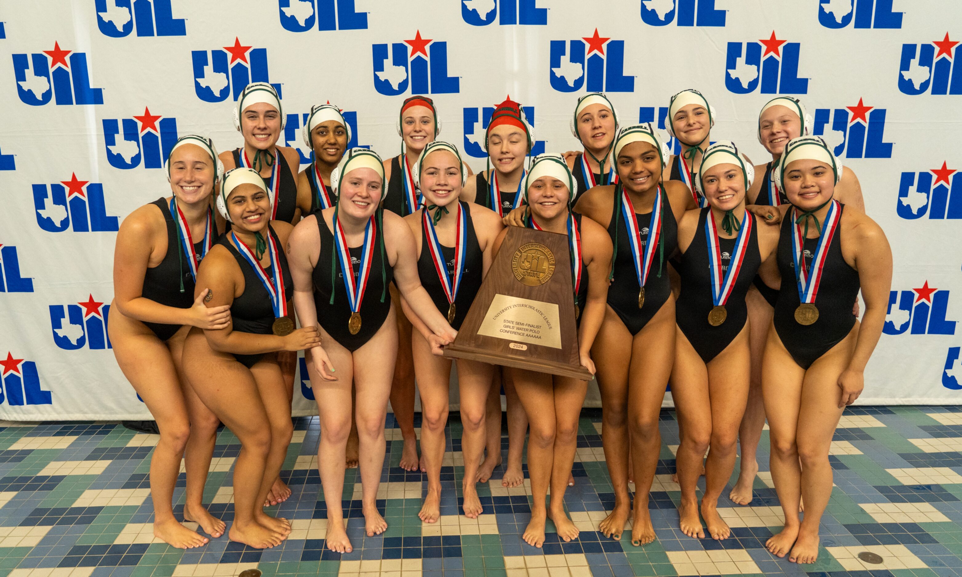 The Southlake Carroll Dragons girls water polo team celebrates with their third-place trophy...