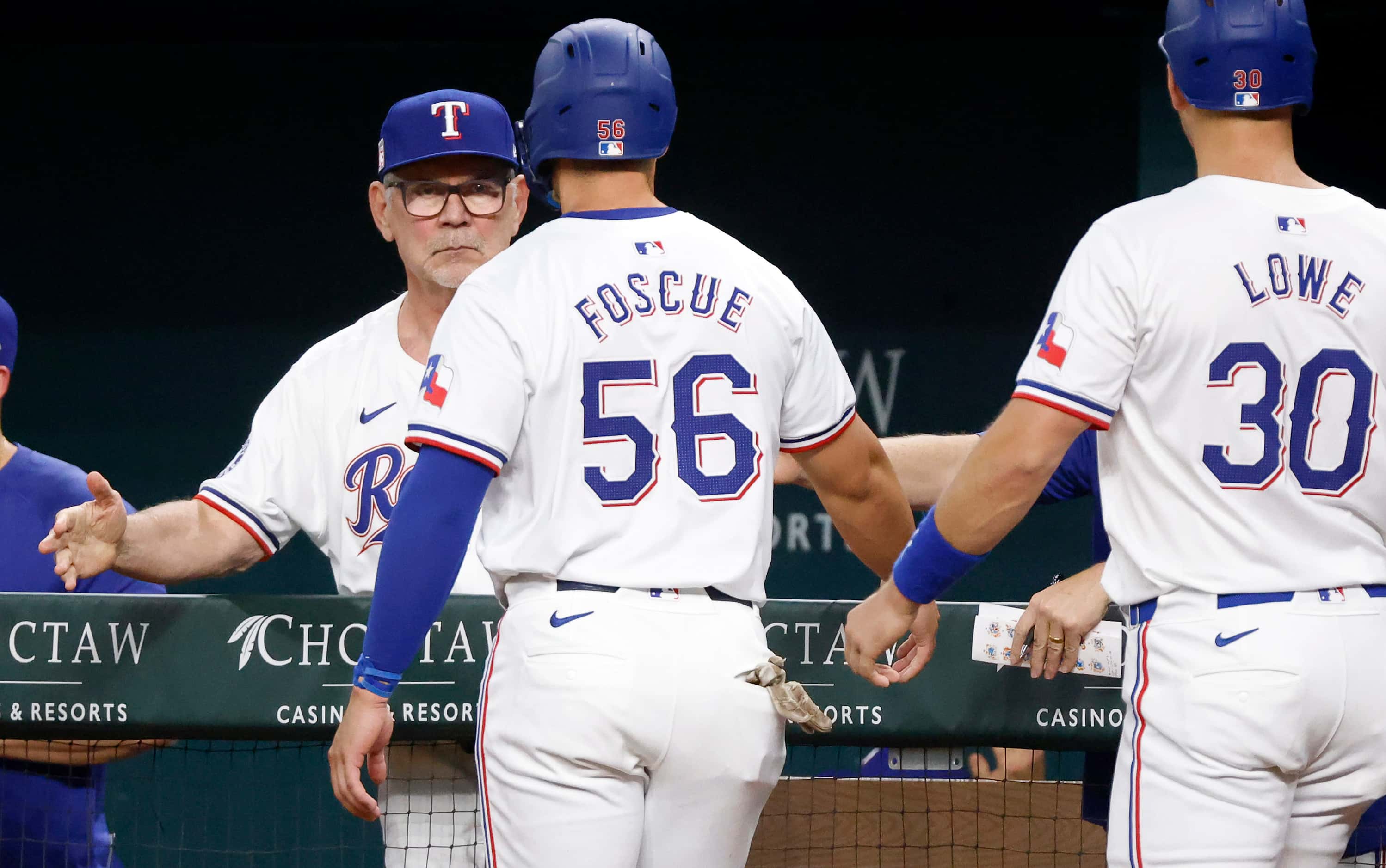 Texas Rangers designated hitter Justin Foscue (56) is congratulated by manager Bruce Bochy...