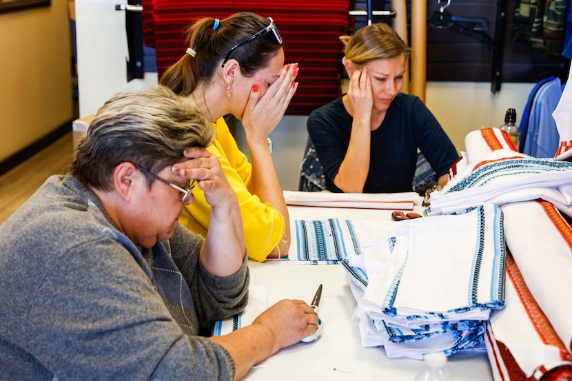 From right, volunteers Oksana Smartt, Oksana Head and Nataliia Partala react after watching...