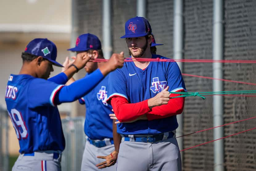 Pitcher Justin Slaten (center) stretches with teammates, including Winston Santos (left),...