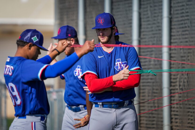 Pitcher Justin Slaten (center) stretches with teammates, including Winston Santos (left),...