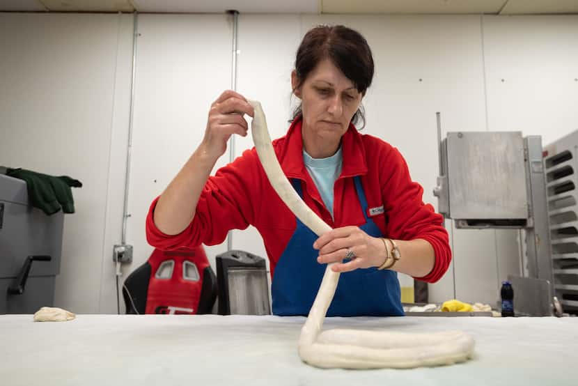 Cook Edija Halilovic twists dough to form a beef pita inside Eddie's EuroMart.
