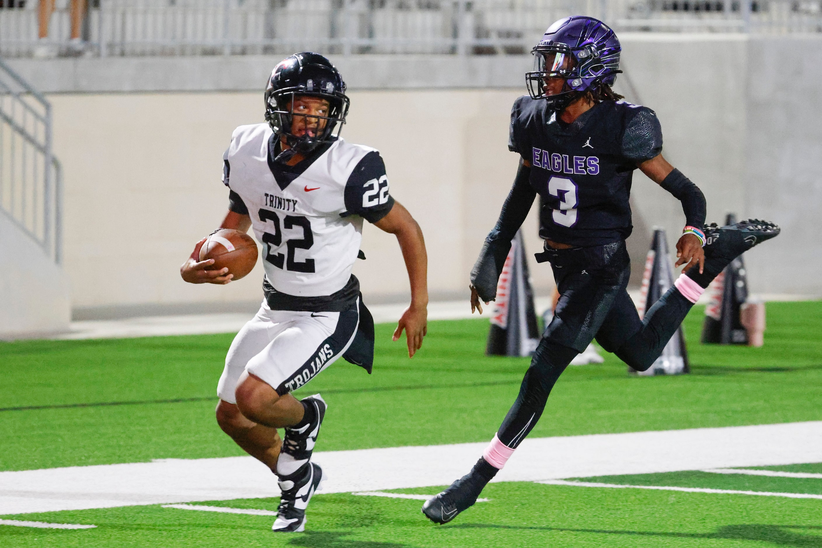 Trinity High’s JT Harris (left) looks back as he runs past Crowley High’s Ja’Corian White to...