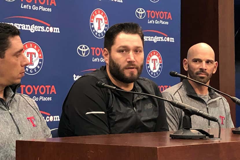 Newly signed Texas Rangers pitcher, Lance Lynn, center, responds to reporters questions as...