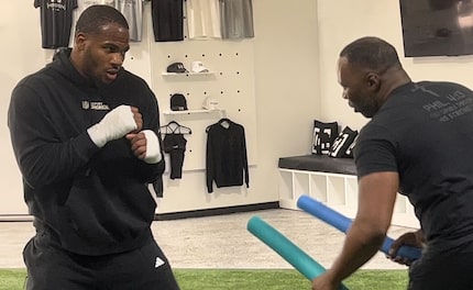 Dallas Cowboys linebacker Micah Parsons (left) prepares to react while Tony Mack holds pool...