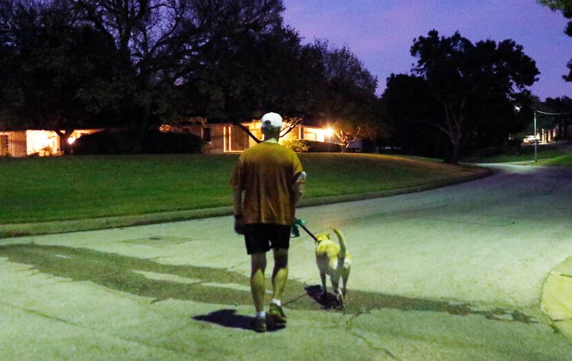 Dr. Alan Johns walks his dog, Zoe, on one of their thrice-weekly predawn walks. The Fort...