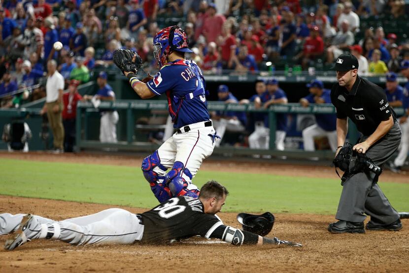 Chicago White Sox's Nicky Delmonico (30) slides safely into home plate after hitting an...
