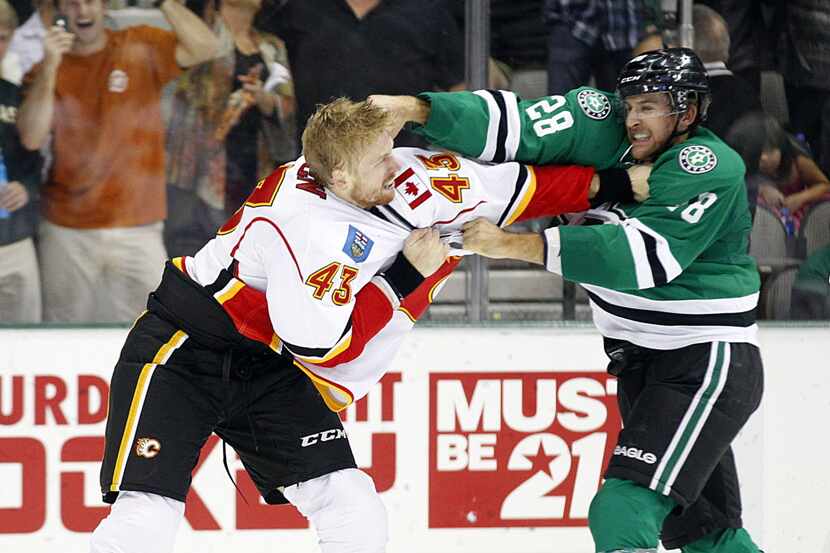 The Dallas Stars' Lane MacDermid (28) and the Calgary Flames' Chris Breen trade punches in...