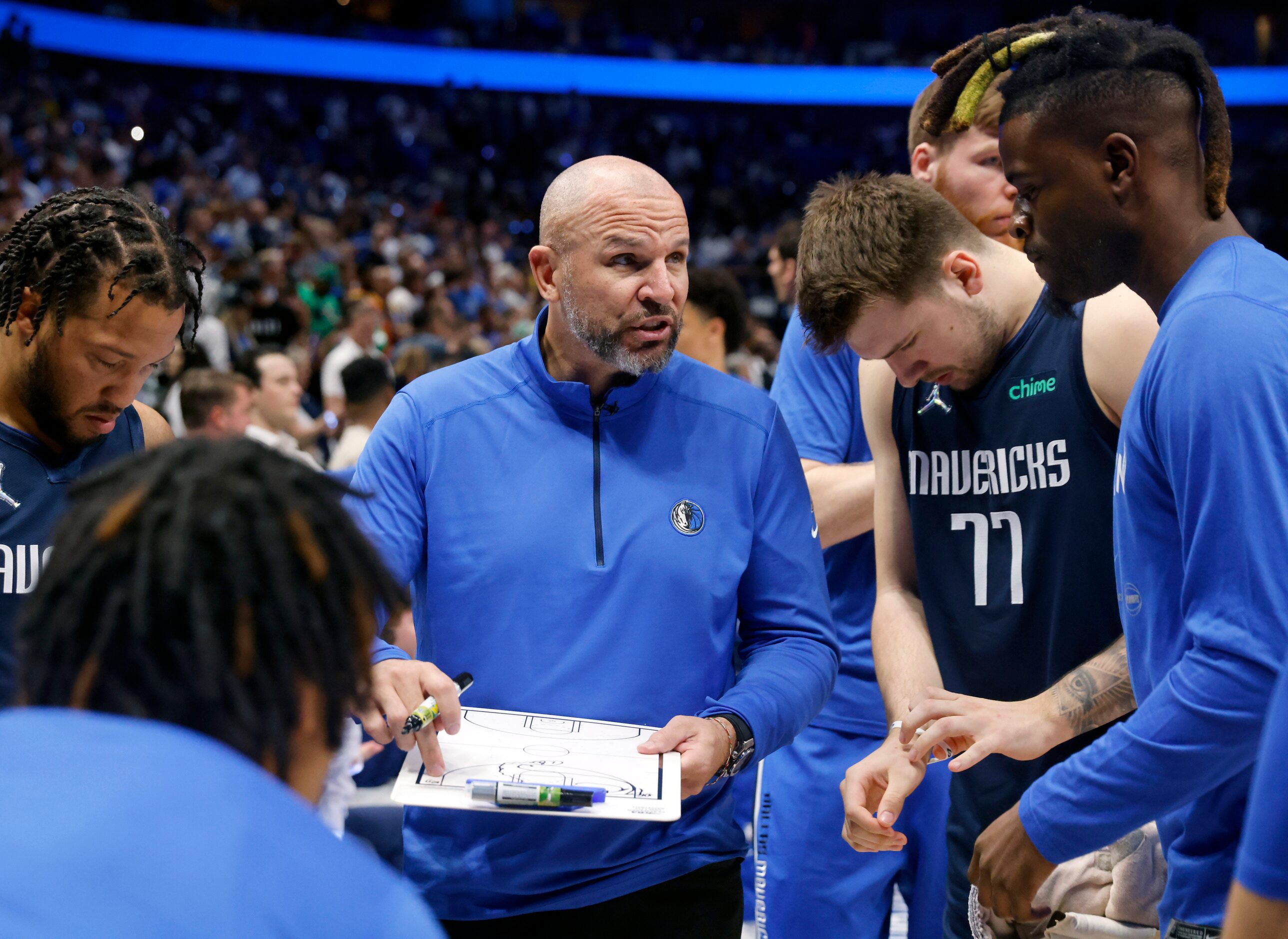 Dallas Mavericks head coach Jason Kidd (center) delivers instruction to guards Jalen Brunson...