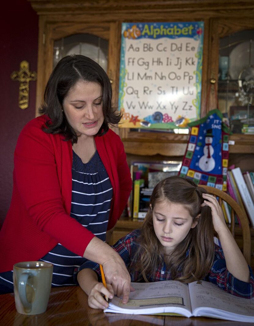 
Maria Kahlig (left) helps her daughter, Molly, with a math lesson at their home. 
