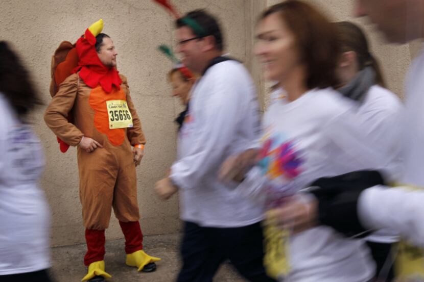 Thomas Lumpkin, wearing a turkey outfit in background, from Irving, TX, waits for his...