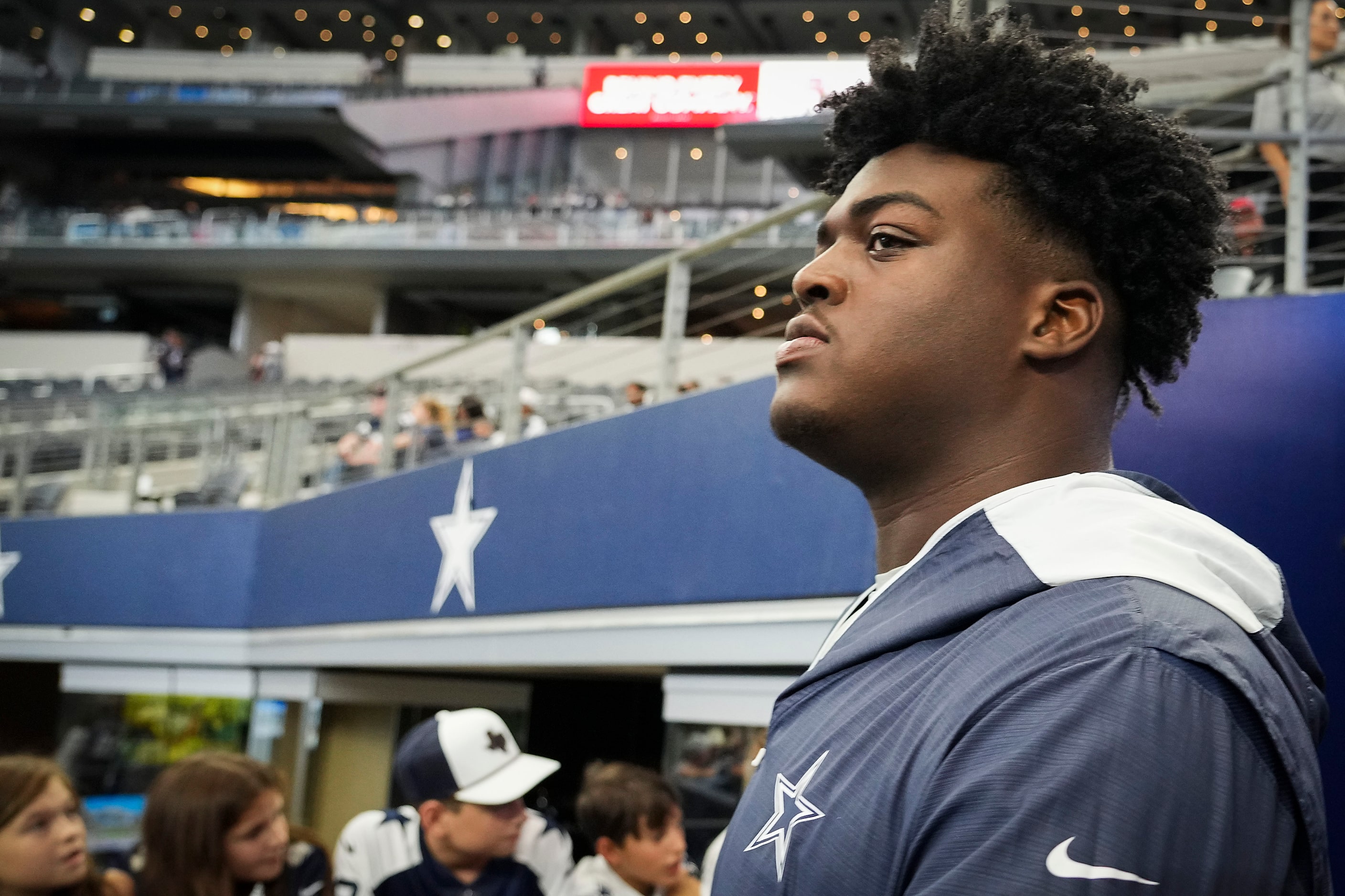 Dallas Cowboys offensive tackle Tyler Smith watches teammates warm up before an NFL...