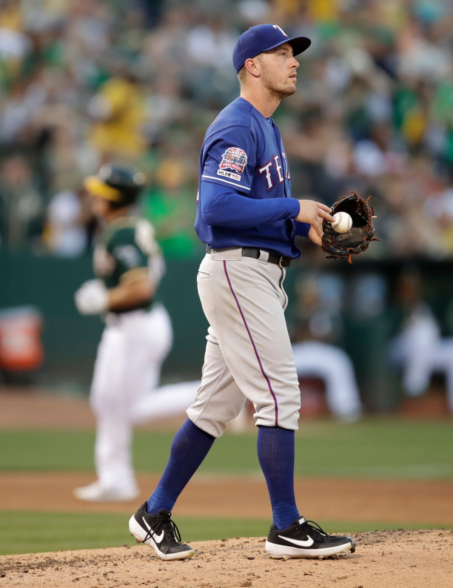 Texas Rangers' Adrian Sampson, right, waits for Oakland Athletics' Matt Chapman to run the...