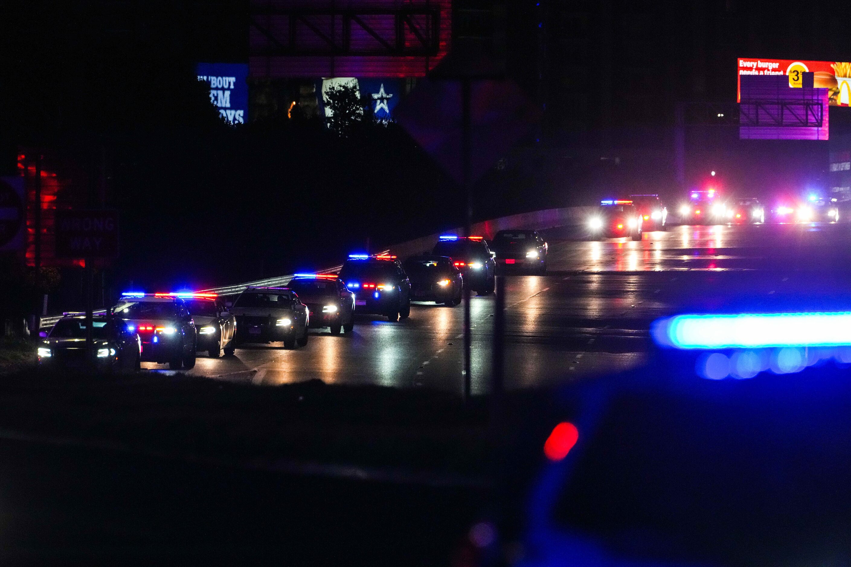 A procession of Dallas police vehicles exits the Stemmons Fwy near the medical examiner’s...