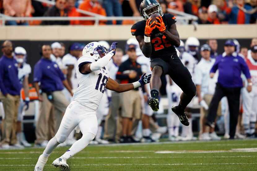 Oklahoma State wide receiver James Washington (28) leaps up for a pass in front of TCU...