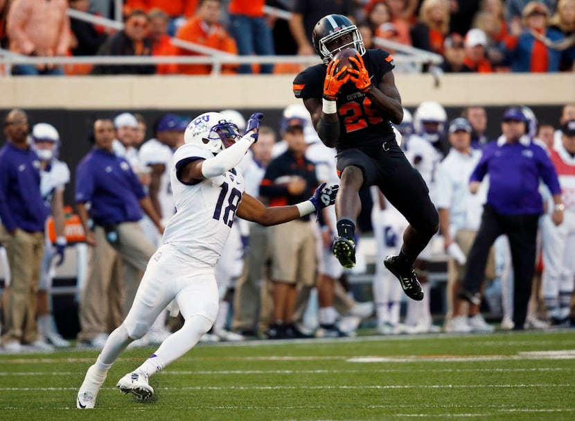 Oklahoma State wide receiver James Washington (28) leaps up for a pass in front of TCU...