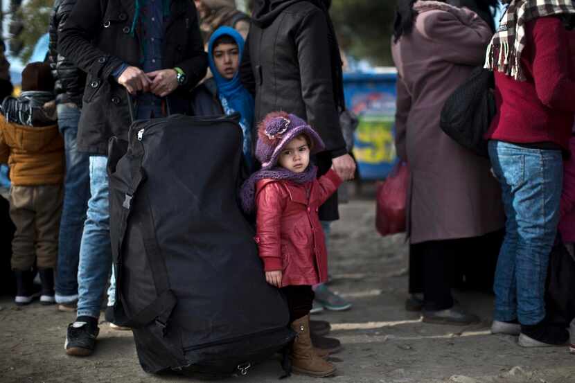 Una familia de refugiados sirios espera para cruzar la frontera entre Macedonia y Grecia....
