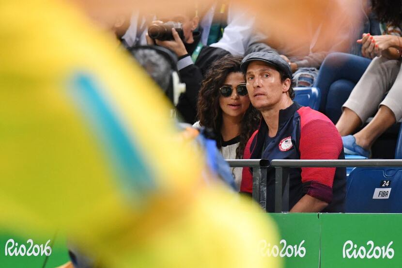 US actor Matthew McConaughey and wife Camila Alves watch the Men's round Group A basketball...