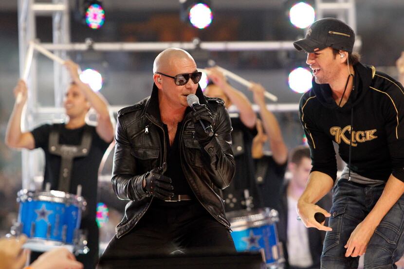 Singers Pitbull (L) and Enrique Iglesias (R) perform at halftime during the Thanksgiving Day...