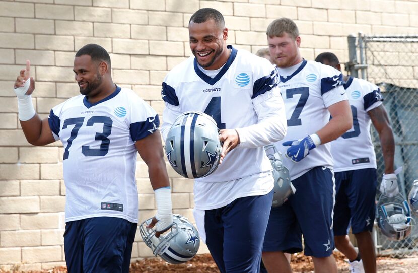 Dallas Cowboys quarterback Dak Prescott (4) laughs as he makes his way onto the field in...