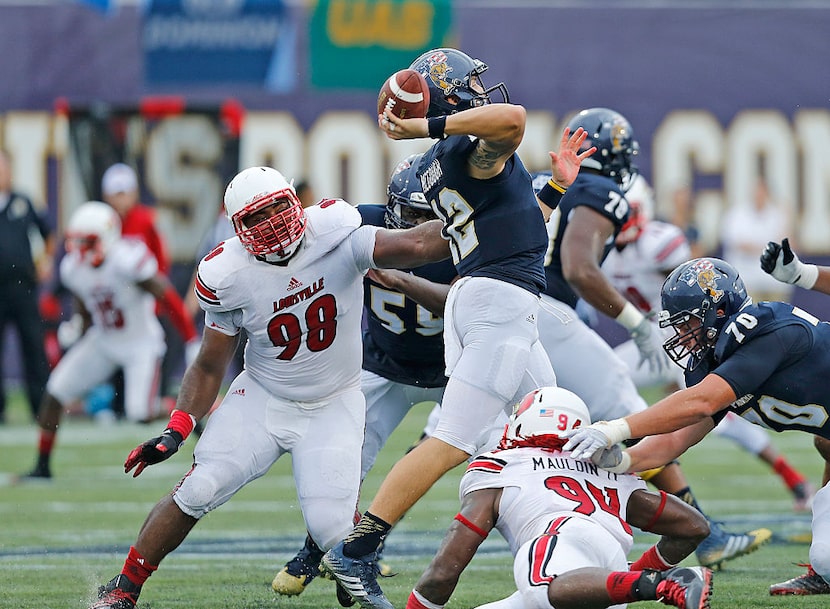 MIAMI, FL - SEPTEMBER 20: Sheldon Rankins #98 of the Louisville Cardinals hits Alex McGough...