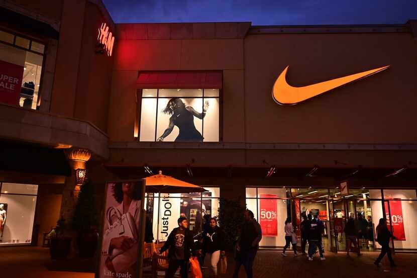 This file photo taken on May 21, 2019, shows shoppers at an outlet mall exit a Nike store in...