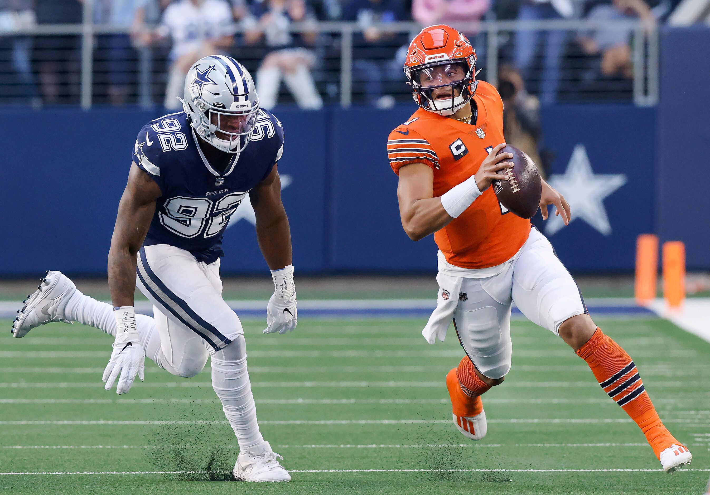 Chicago Bears quarterback Justin Fields (1) races to the edge as he is pursued by Dallas...