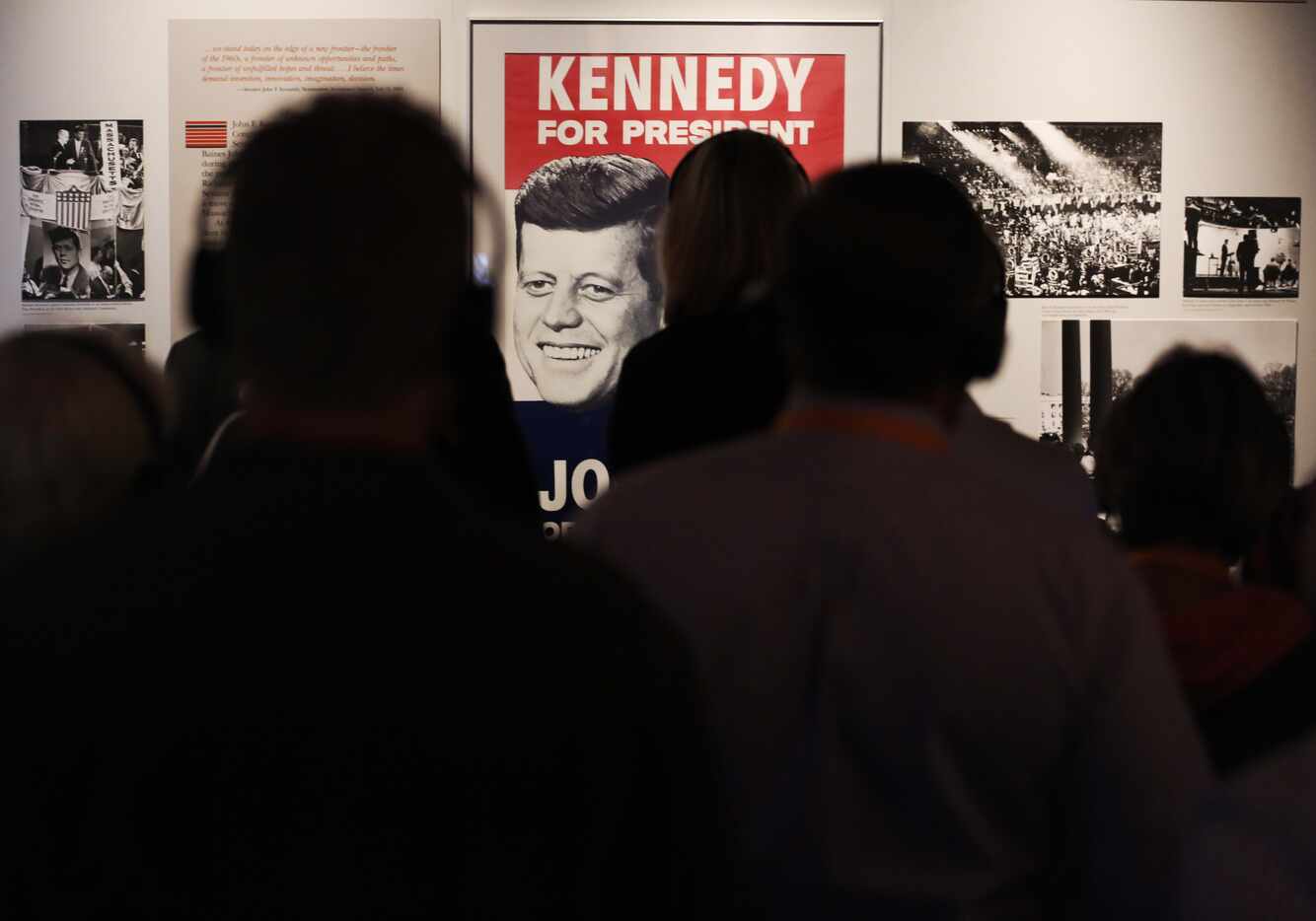 Museum patrons study the history of President John F. Kennedy at the Sixth Floor Museum in...