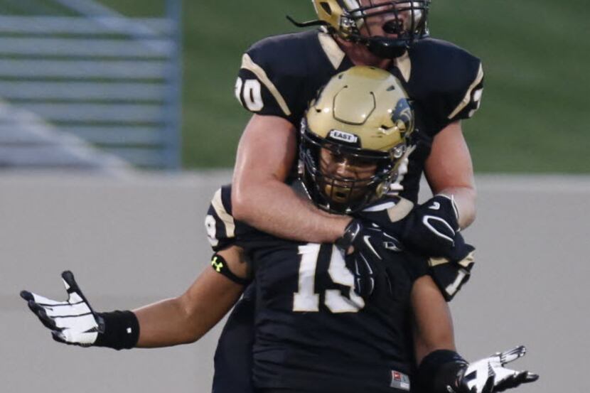 Plano East High School defensive lineman Grayson Diepenbrock (30) leaps onto the back of...