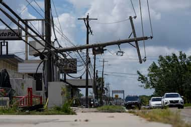 Traffic is directed around a downed power line in Houston, Tuesday, July 9, 2024. After...