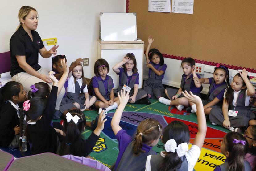Claudia Capetillo, first grade teacher, left, talks to her students on the first day of...