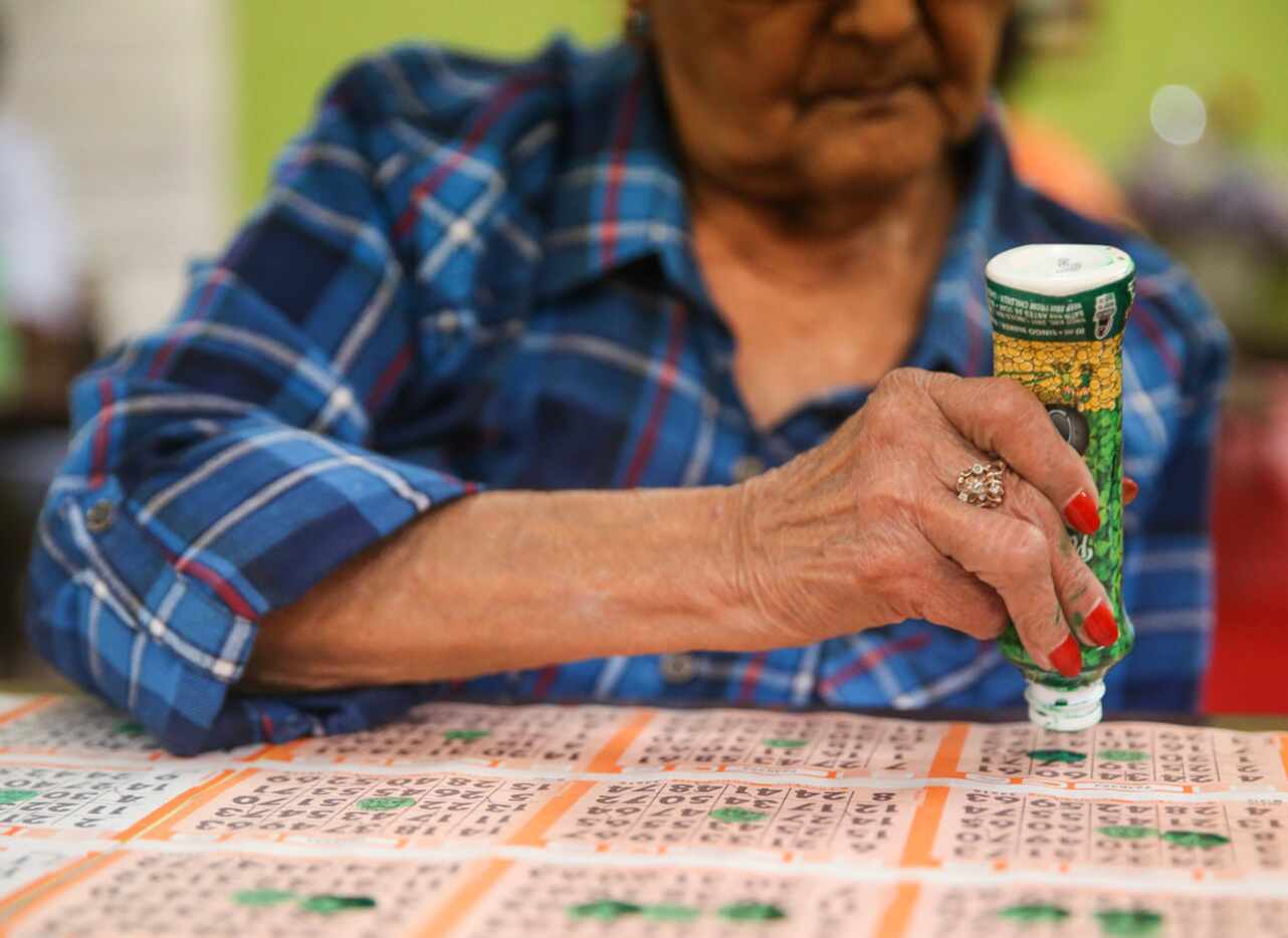 Rosa Corona, of Dallas, marks her bingo cards during a round of bingo at Jackpot Bingo on...