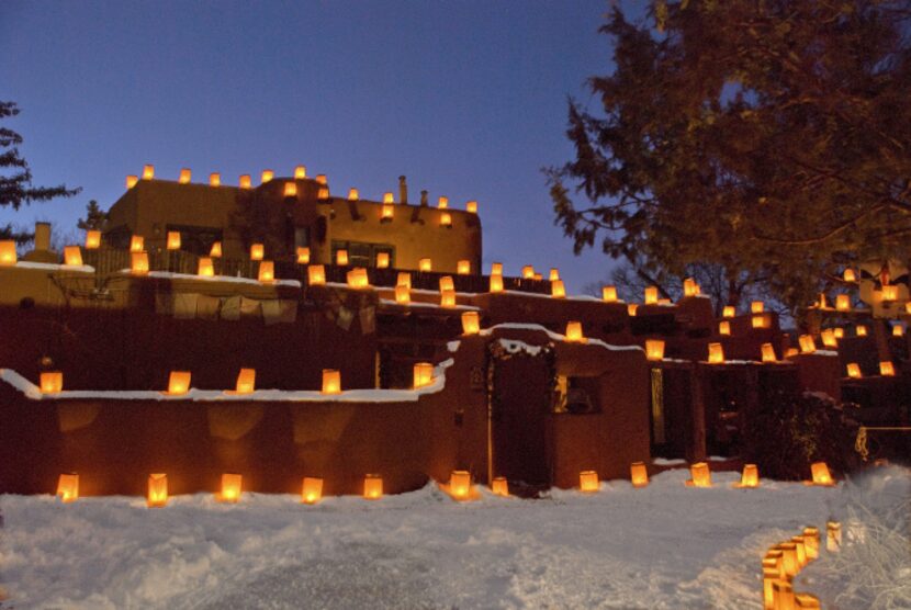 Plaza Fatima on Christmas Eve __ Caption: Thousands of candlelit farolitos top adobe walls...