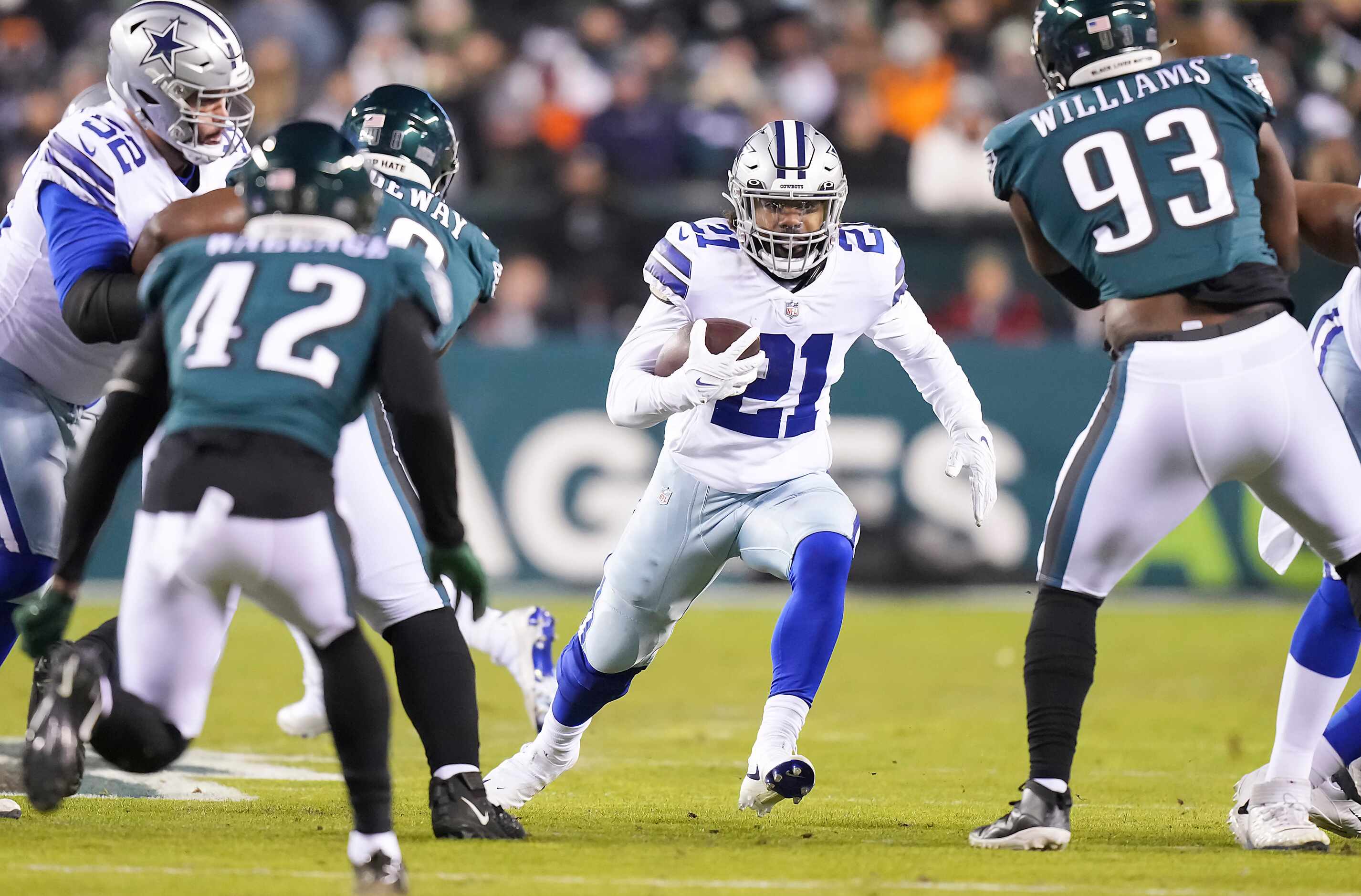 Dallas Cowboys running back Ezekiel Elliott (21) finds a hole between Philadelphia Eagles...
