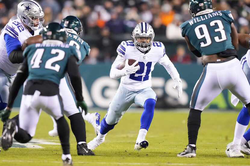 Dallas Cowboys running back Ezekiel Elliott (21) finds a hole between Philadelphia Eagles...