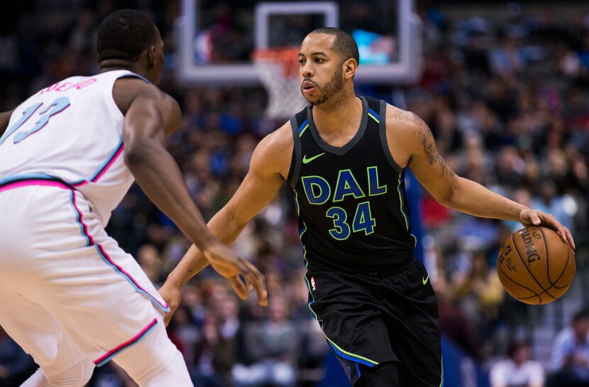 Dallas Mavericks guard Devin Harris (34) looks for a pass around Miami Heat center Bam...