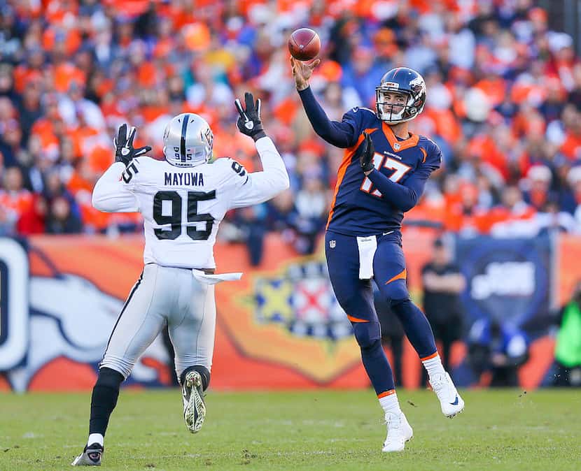 DENVER, CO - DECEMBER 13:  Quarterback Brock Osweiler #17 of the Denver Broncos passes under...