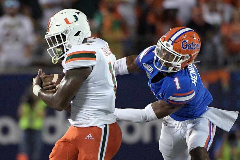 Miami running back DeeJay Dallas (13) rushes for yardage as Florida defensive back CJ...