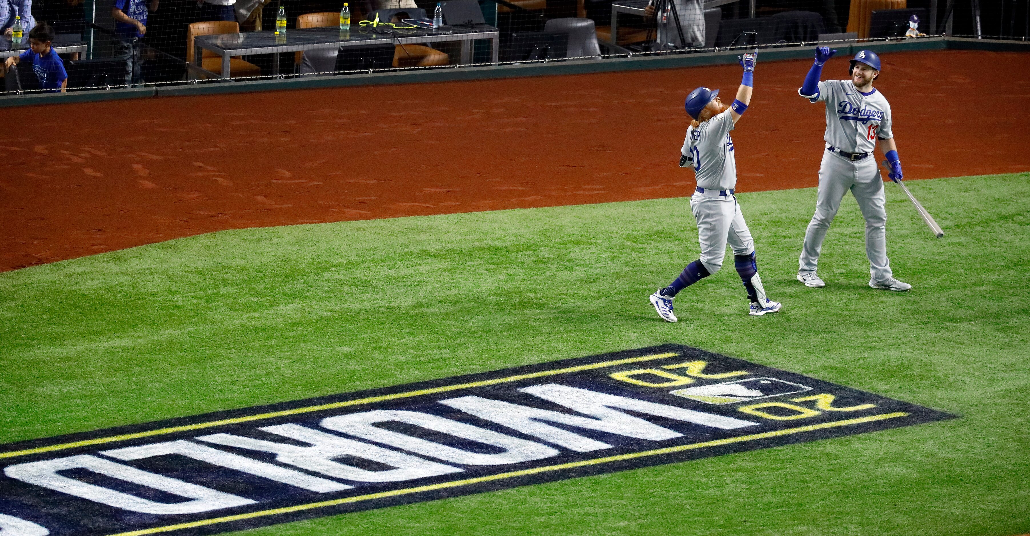 Los Angeles Dodgers Max Muncy (13) congratulates teammate baseman Justin Turner (10) on his...