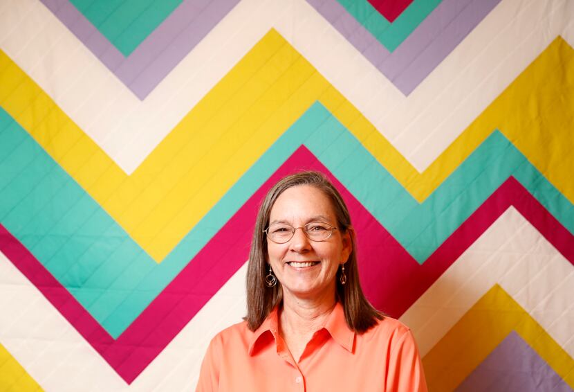 A portrait of Belinda Gelhausen who made quilts (in background) at Citycraft in Dallas, TX.
