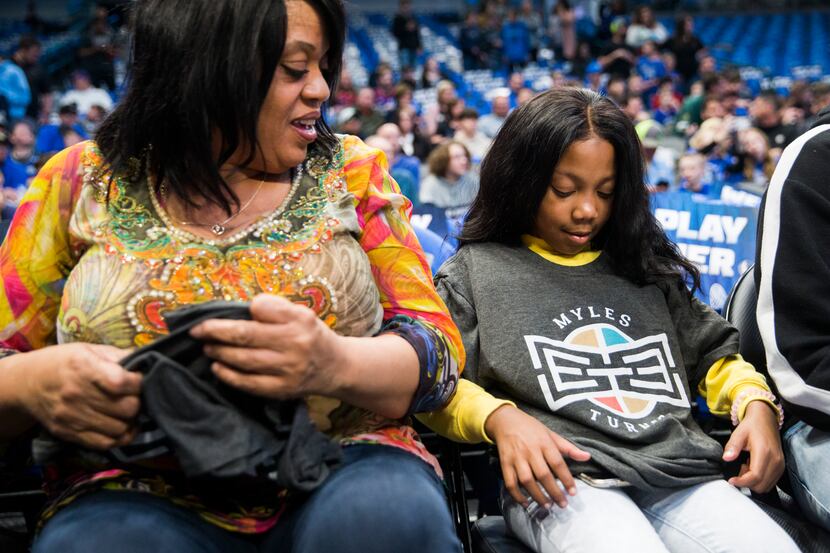 A'Myah Moon, 11, puts on a T-shirt with Indiana Pacers center Myles Turner's No 33 as her...