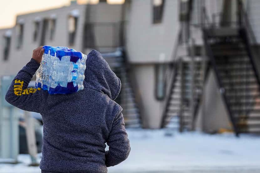 A man walked home with drinking water that was distributed at the nonprofit Literacy...