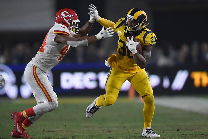 LOS ANGELES, CA - NOVEMBER 19:  Todd Gurley #30 of the Los Angeles Rams fends off Dorian...