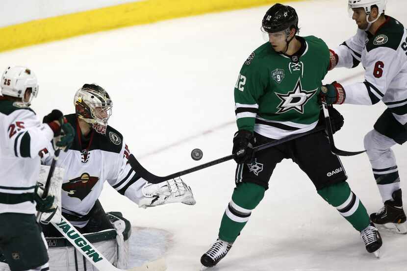 Minnesota Wild goalie Darcy Kuemper (35) stops the puck next to Dallas Stars right wing Alex...