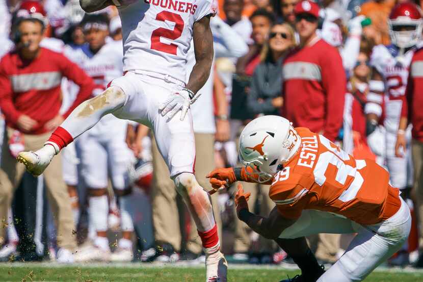 Oklahoma wide receiver CeeDee Lamb (2) spins away from Texas defensive back Montrell Estell...