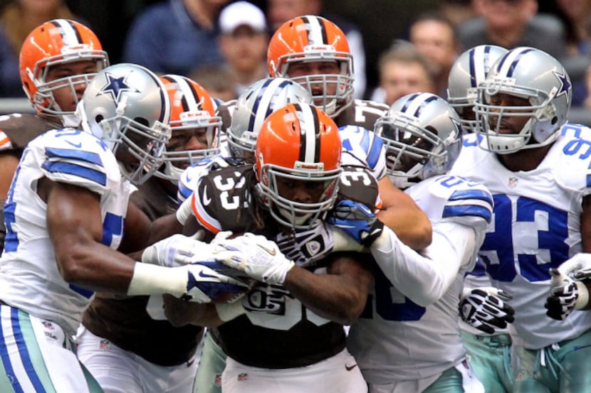 A host of Dallas defenders stop Cleveland running back Trent Richardson (33) in the first...