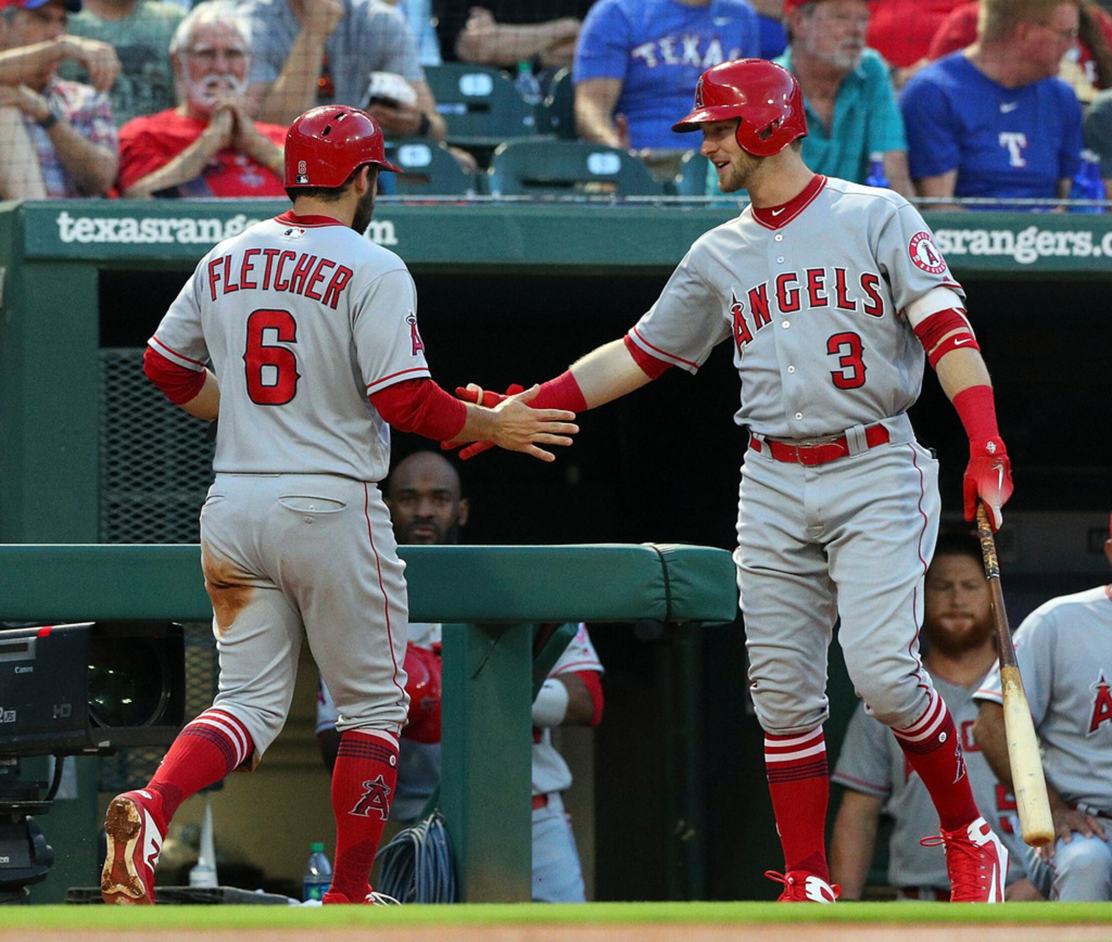 Los Angeles Angels' David Fletcher (6) is greeted at the dugout by Taylor Ward after scoring...