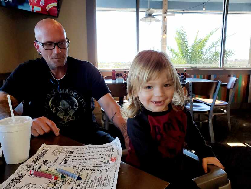 Shane Douglas Semsroth of Houston sits with his 2-year-old son, Rayder.