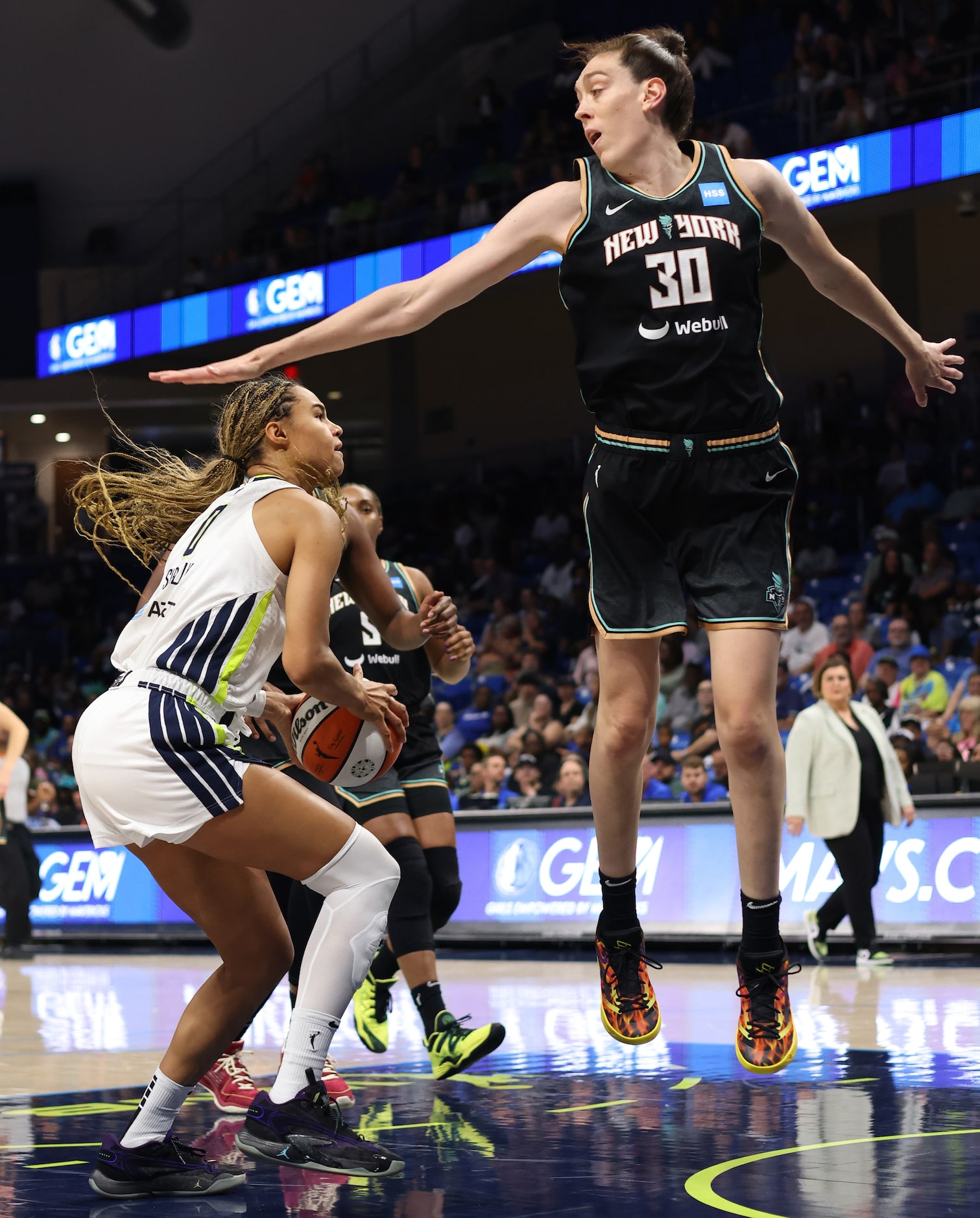 Dallas Wings forward Satou Sabally (0), left, prepares to shoot around the defense of New...