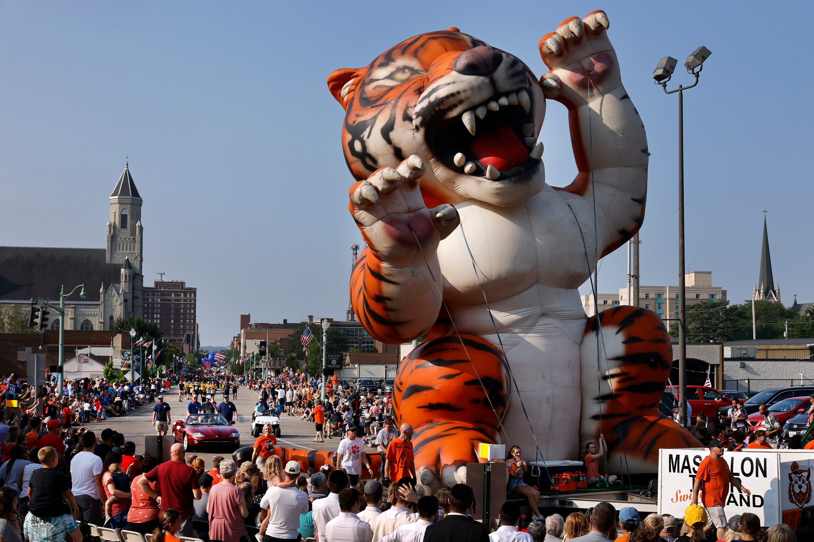 Large inflatable floats combined with marching bands and classic cars carrying Pro Football...